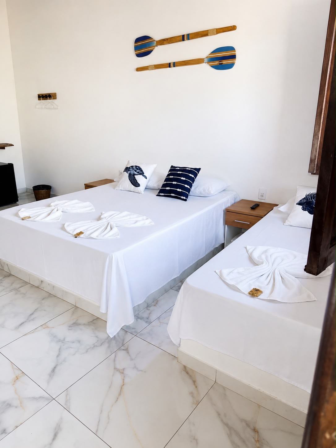 Quarto com toalhas decorativas e remos na parede